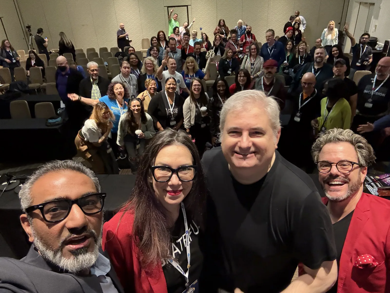 Junaid Ahmed on stage with fellow speakers and the audience at Podfest 2025